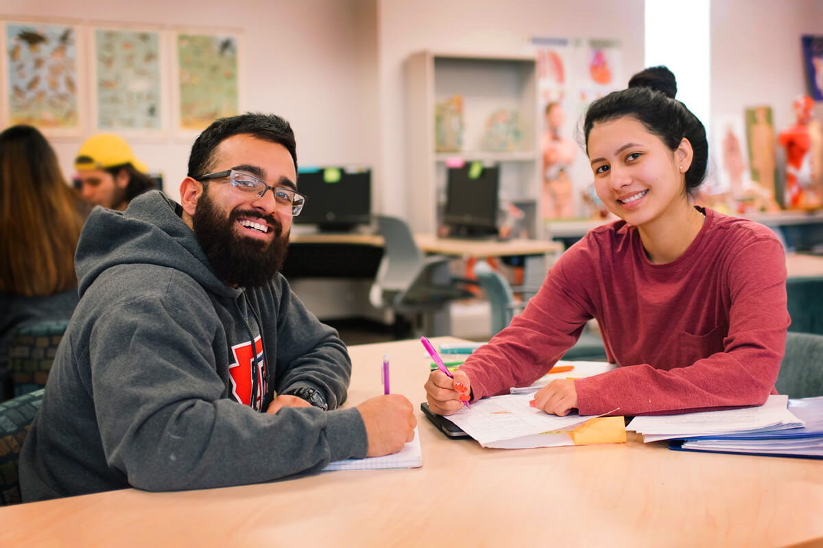 Two student working at a table in the Pima Community College library.