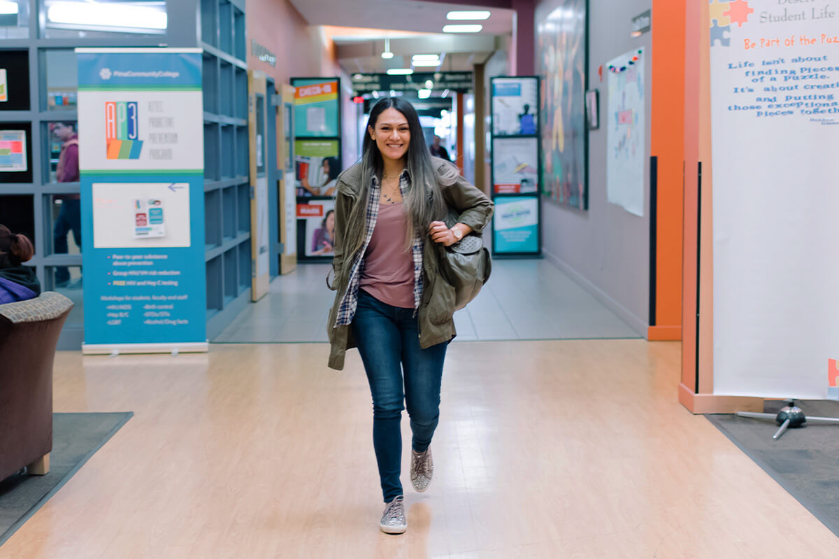 Student walks the hallway of a pima community college campus.