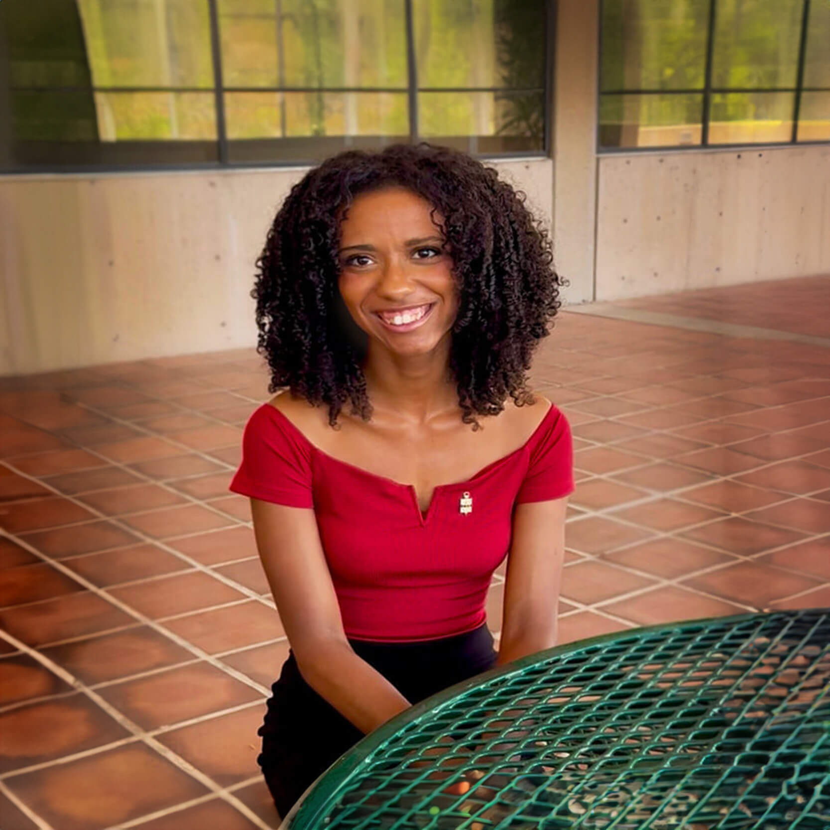 Malyssa  sits smiling at a table in a Pima Campus breezeway
